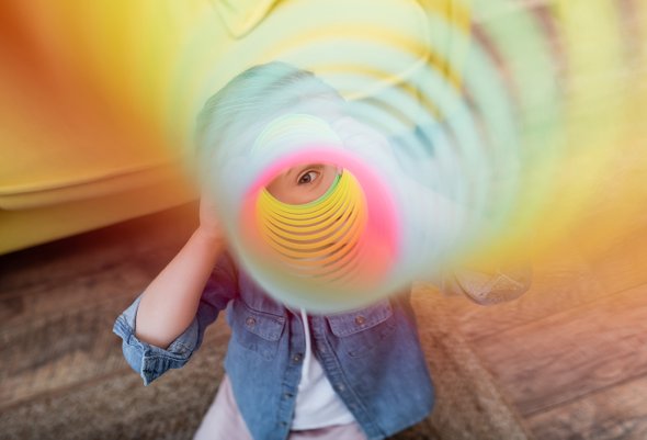 Девочка ребенок смотрит через игрушку пружинку слинки. 3 базовых навыка, которые должны быть у каждого ребенка