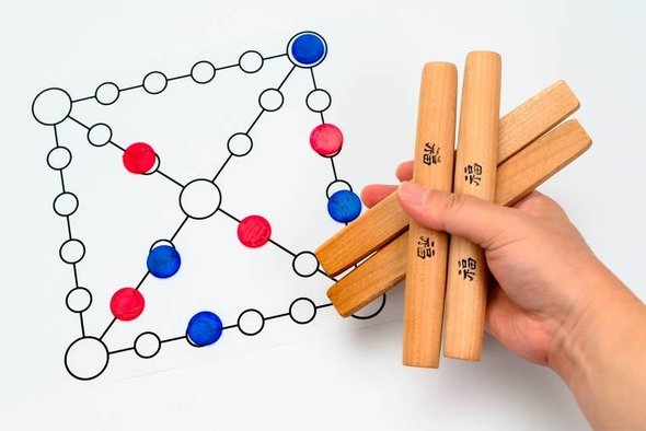 Фишки, игровое поле и палочки для игры в юннори. Фото: Ju Jae-young / Shutterstock / Fotodom