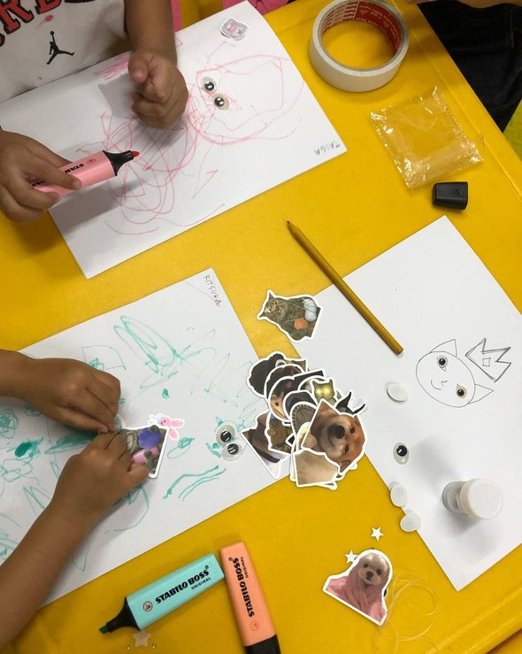 Ученики рисуют на листах бумаги и приклеивают милые картинки животных