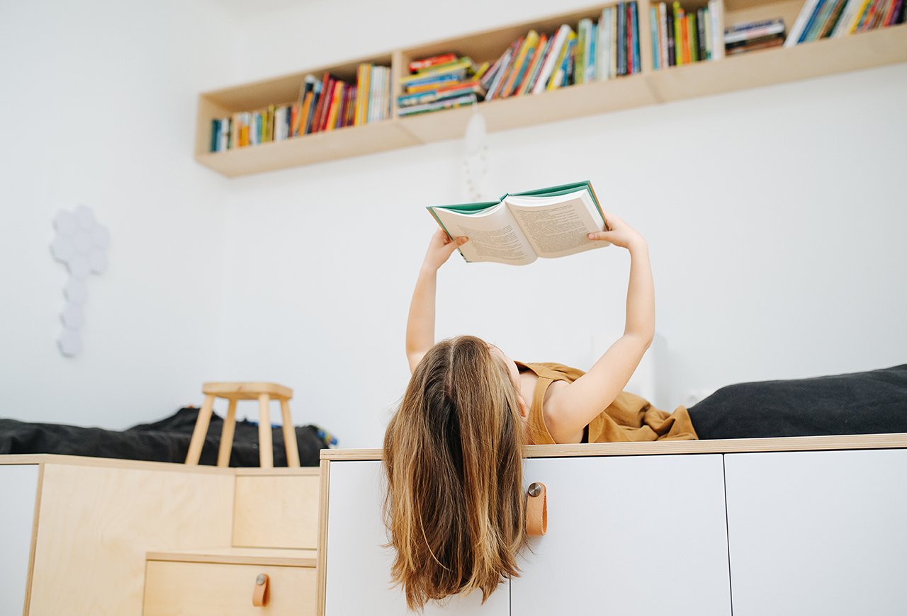 She reads a lot. Девушка лежит с книгой. Девушка лежит над книгами на прозрачном фоне. Девочка лежит бесконечный учебник.
