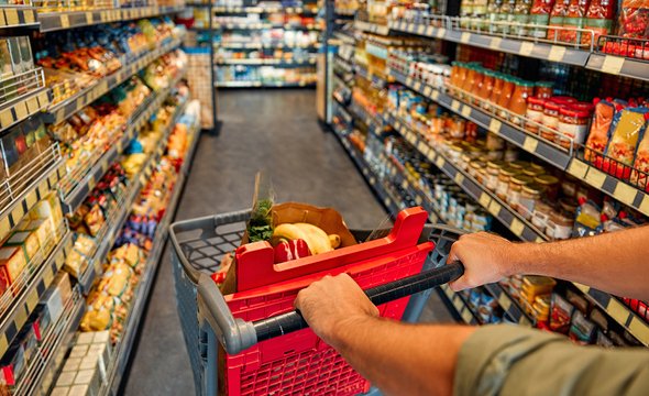 Мужчина с корзиной в супермаркете. Продуктовый магазин