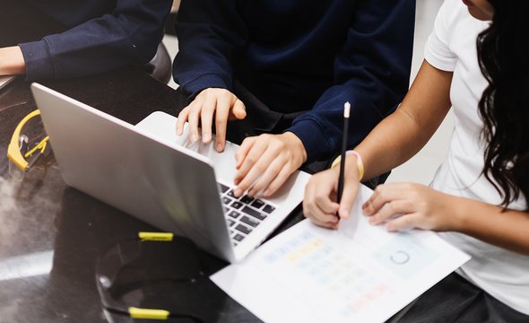 Школьники в форме на уроке в частной школе используют ноутбук