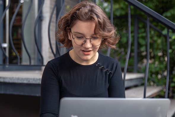 Девушка сидит за ноутбуком. Фронтенд-разработчик. 5 IT-направлений для ребенка, который не дружит с математикой