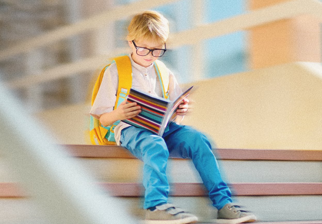 школьник читает книгу на ступеньках