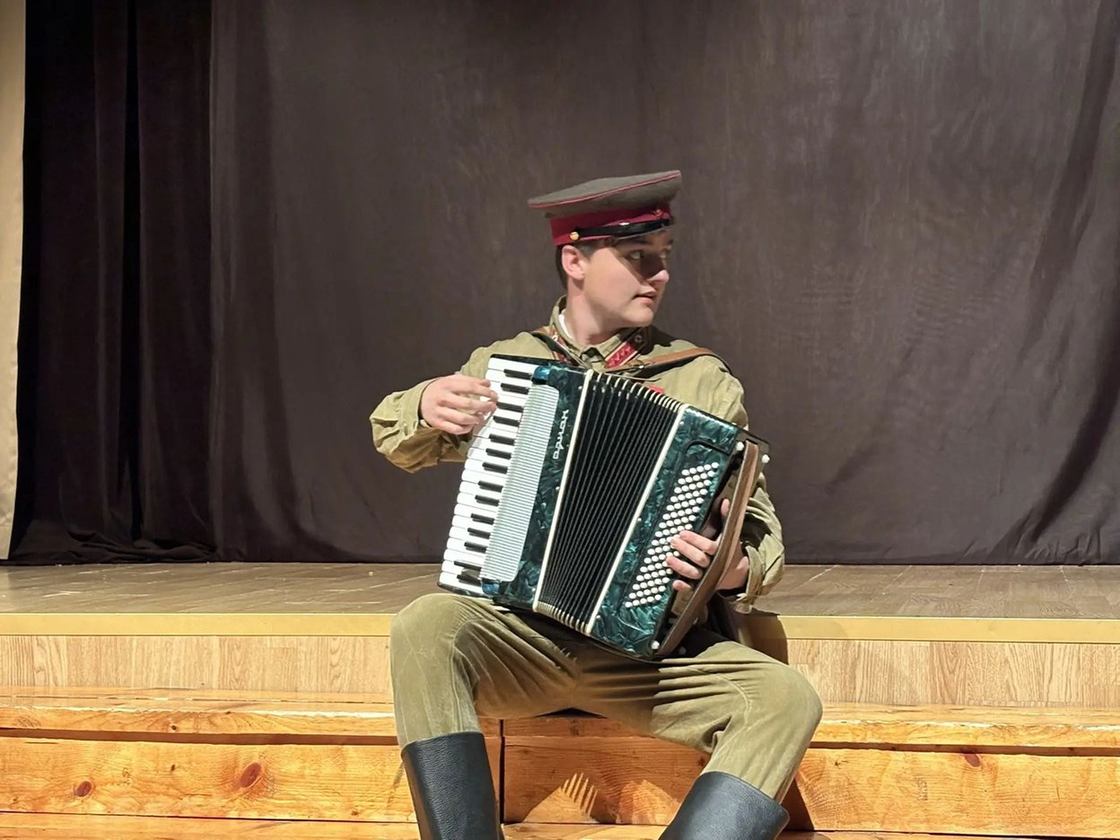 школьник играет на баяне