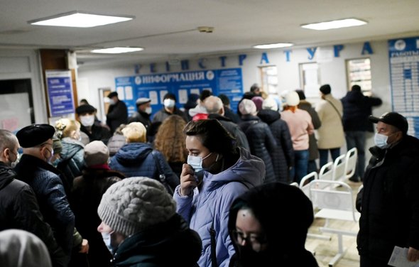 Люди в регистратуре в поликлинике. Очередь