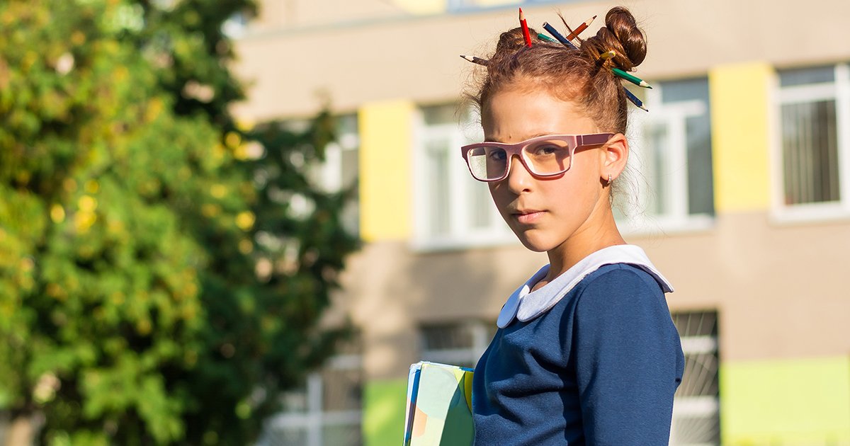 Молодой школьник девушка. Русская девушка в очках рядом со школой.