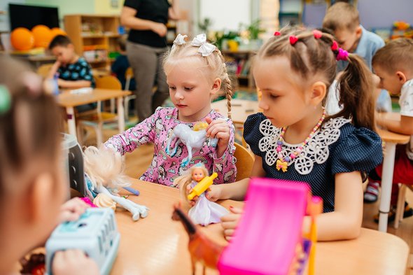 Дети в детском саду играют в куклы