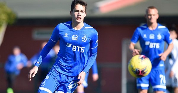 молодой футболист с мячом на поле в форме Динамо