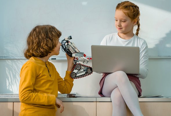 Мальчик и девочка занимаются программированием и робототехникой. Курсы программирования для детей