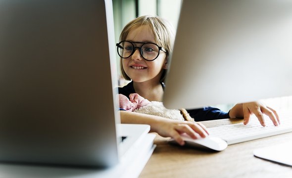 Девочка сидит за компьютером и смотрит в ноутбук. Курсы программирования для детей